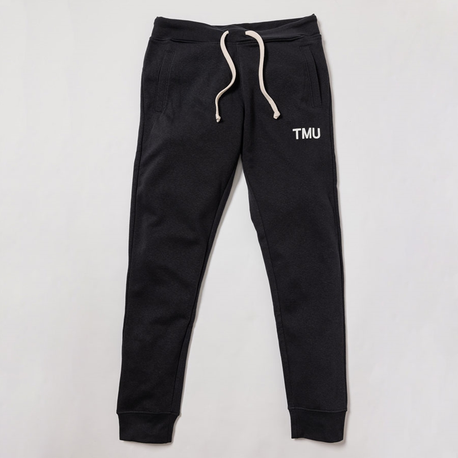 A black fleece sweatpant features "TMU" on the left hip, printed in white.
